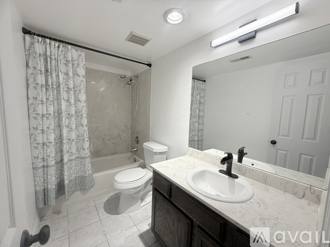 A bathroom with a toilet, sink, and shower.
