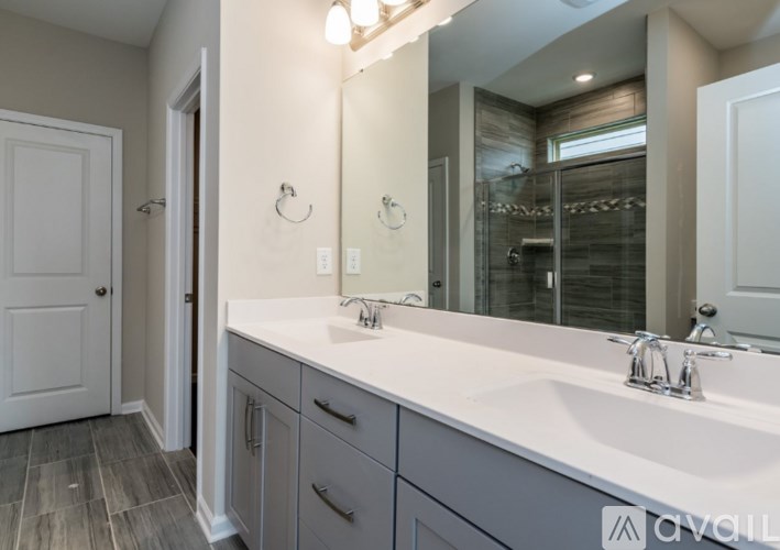 A bathroom with a white sink and a large mirror.
