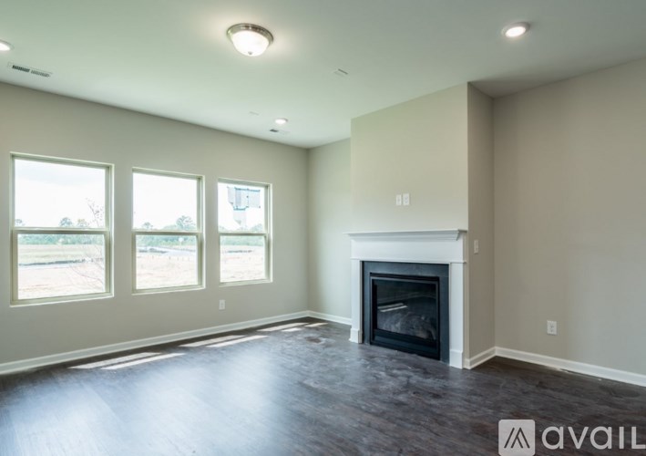 A spacious living room with a fireplace and large windows.