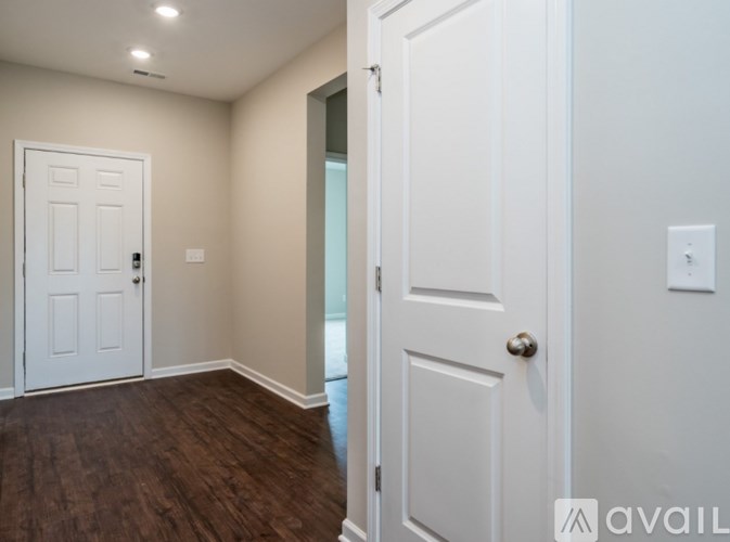 A room with a white door and a wooden floor.