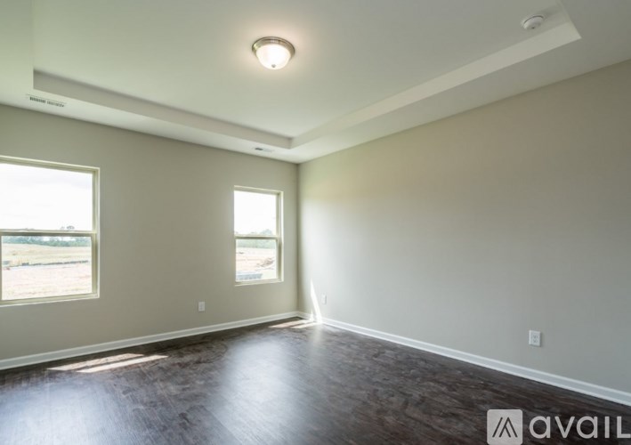 A room with a window and a wooden floor.