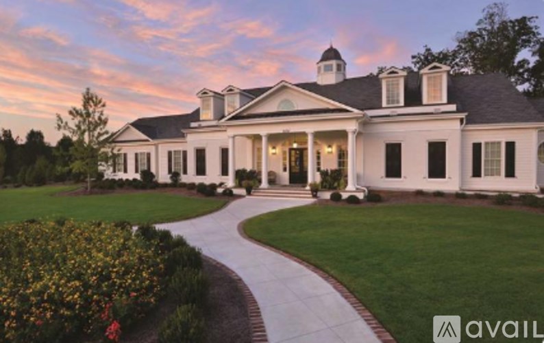 A large white house with a circular driveway in front.