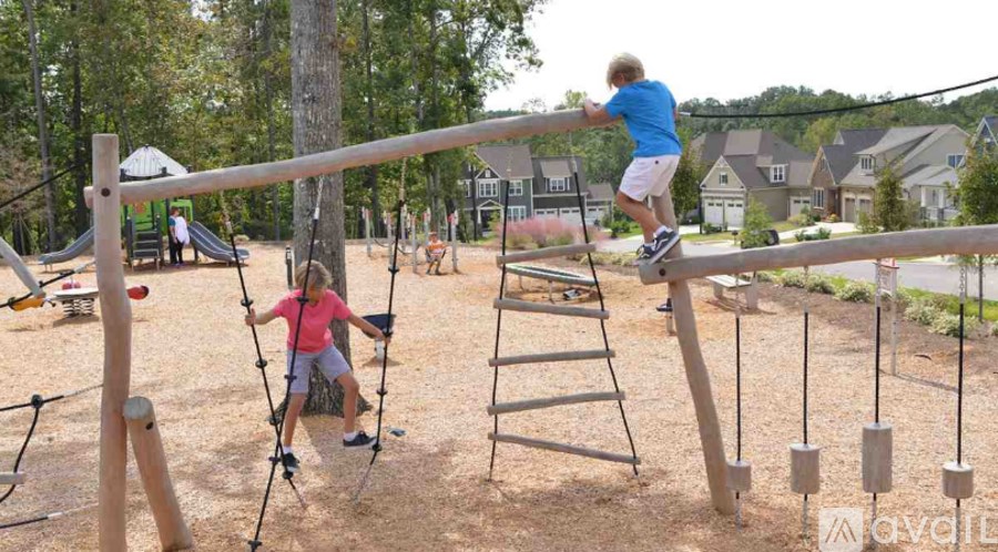 A child in a red shirt is swinging on a swing set.
