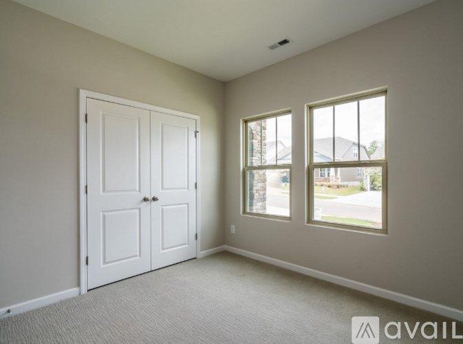 A room with a white door and a window showing a view of a street.
