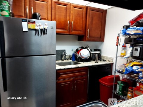 A kitchen with a refrigerator and a sink.