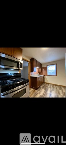 A kitchen with wooden cabinets and a black stove top oven.