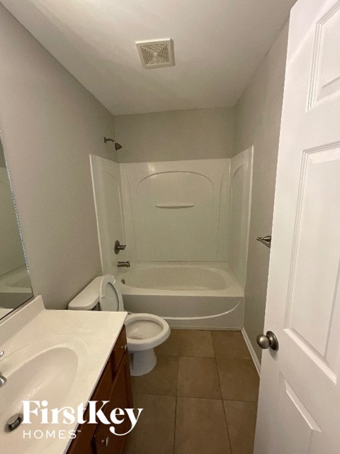 A white bathroom with a toilet, sink, and bathtub.
