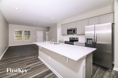 A kitchen with a white counter top and stainless steel appliances.
