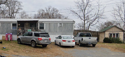 A silver SUV is parked in front of a silver car and a white car.