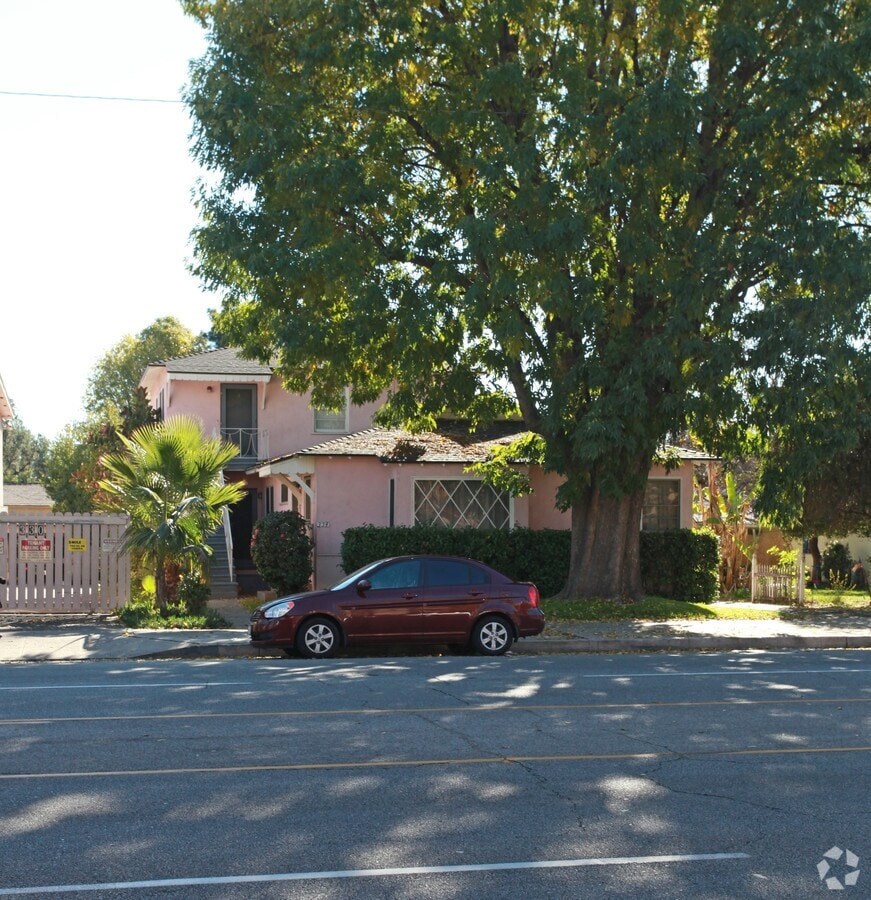 A red car is parked on the side of a street.