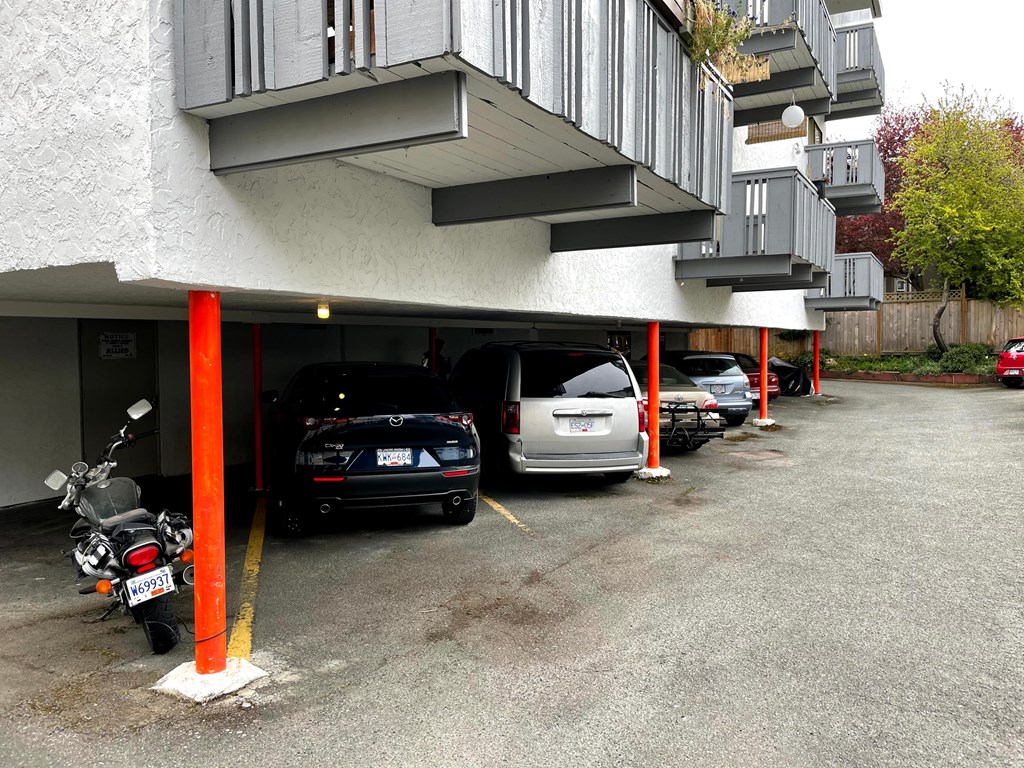 A parking lot with cars and a motorcycle.