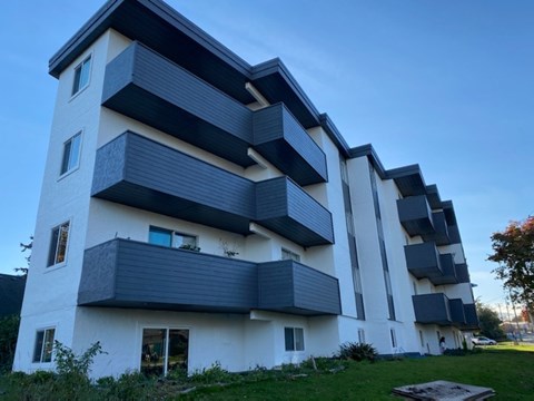 A modern multi-story building with balconies and windows.
