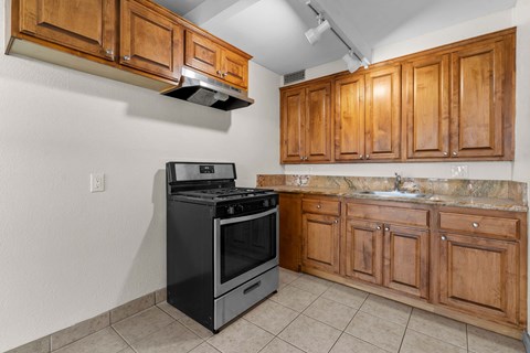 A kitchen with wooden cabinets and a black stove top oven.