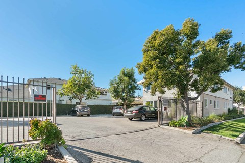 A gated entrance to a residential area with a car parked in front.