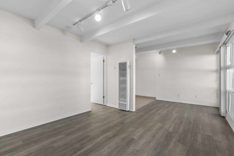 A room with a white wall and a wooden floor.