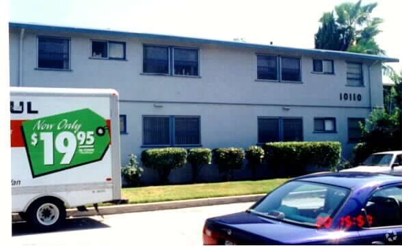 A car is parked in front of a building with a Lowe's sign in the foreground.