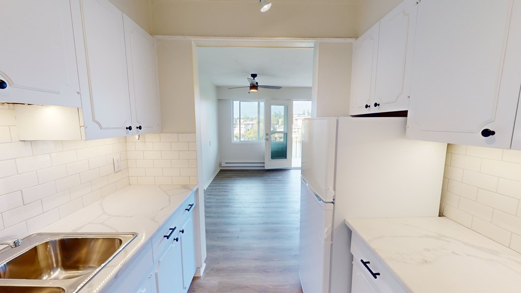 A kitchen with white cabinets and a sink.