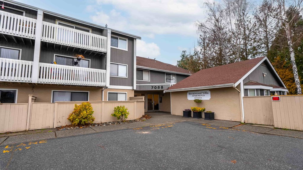 A large apartment complex with a small building in front of it.