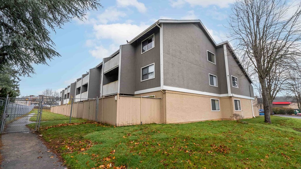 A modern apartment building with a grey and beige exterior.