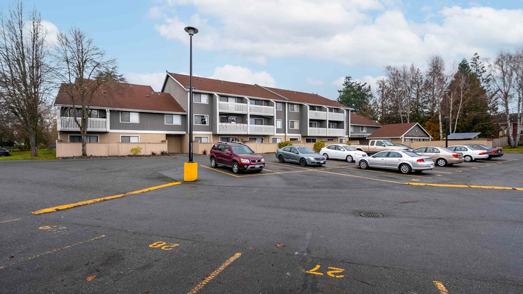 A parking lot with cars and a building in the background.
