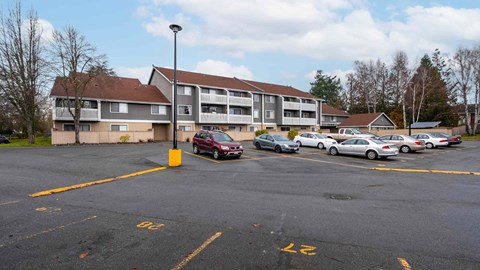 A parking lot with cars and a building in the background.