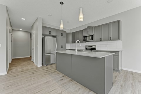 A modern kitchen with a large island and stainless steel appliances.