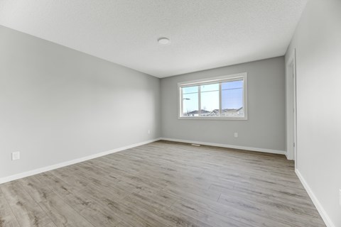 A room with a window and wooden flooring.