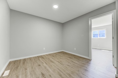 A room with light grey walls and wooden flooring.
