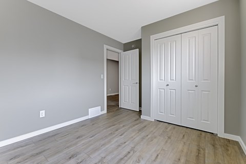 A room with a grey wall and a white door.