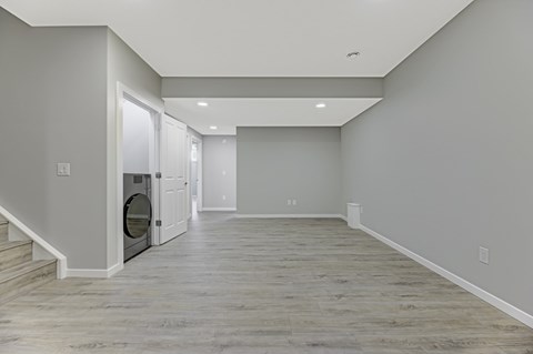 A spacious room with a washer and dryer built into the wall.