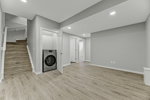 A modern room with a washer and dryer built into the wall.