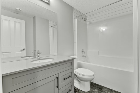 A white bathroom with a sink, toilet, and bathtub.