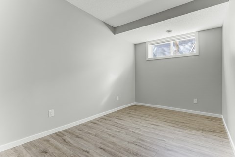 A room with a window and wooden flooring.
