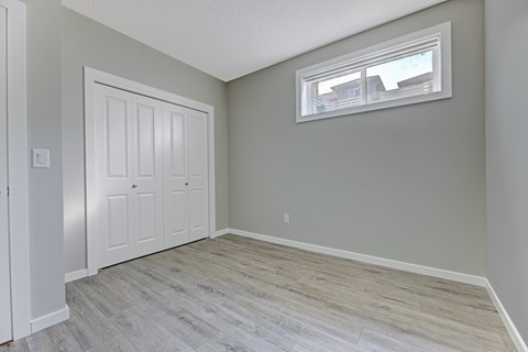 A room with a white door and a window with a white frame.