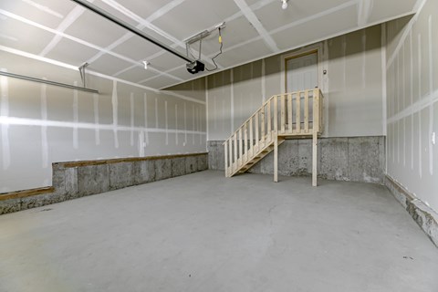 A room with a wooden staircase and white walls.