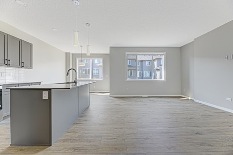 A kitchen with a grey counter and wooden floors.