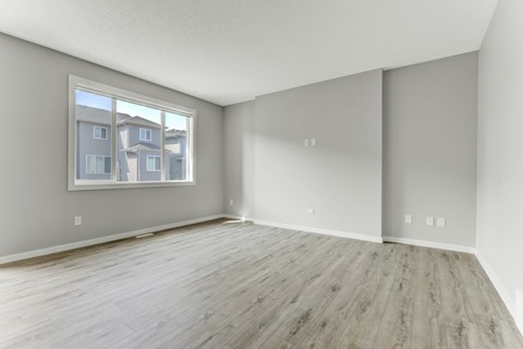 A room with a large window and wooden flooring.