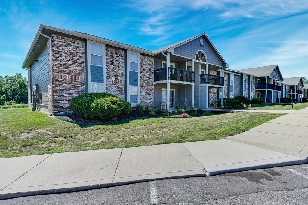 A row of houses with a sidewalk in front.