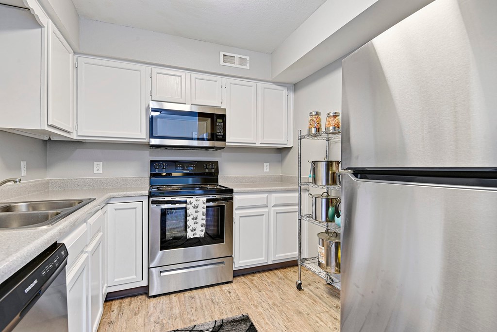A kitchen with white cabinets and stainless steel appliances.
