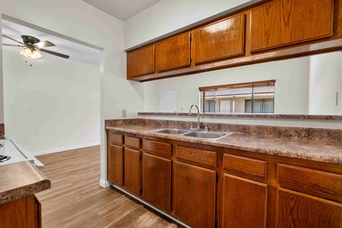 A kitchen with wooden cabinets and a marble countertop.