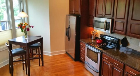 A kitchen with a table and chairs and a refrigerator.