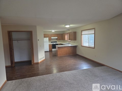 A spacious living area with a kitchen in the background.