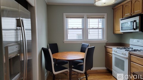 A kitchen with a table and chairs in front of a window.