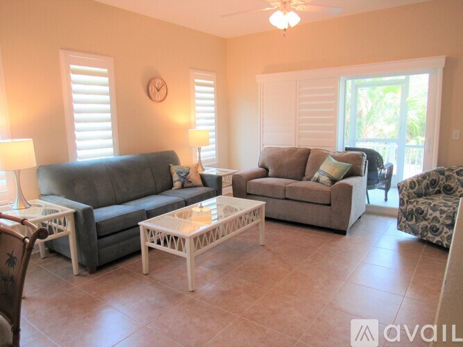A living room with a grey couch, a white coffee table, and a lamp.