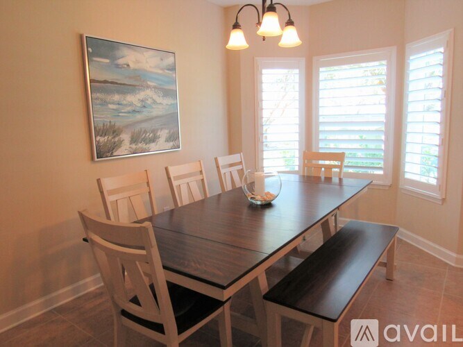 A dining room with a wooden table and chairs.