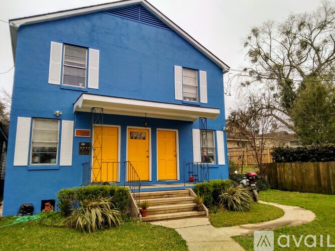 A blue house with a yellow door and white trim.