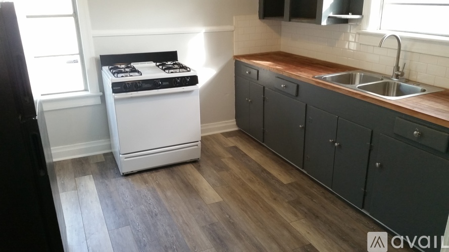 A kitchen with a white stove and black cabinets.
