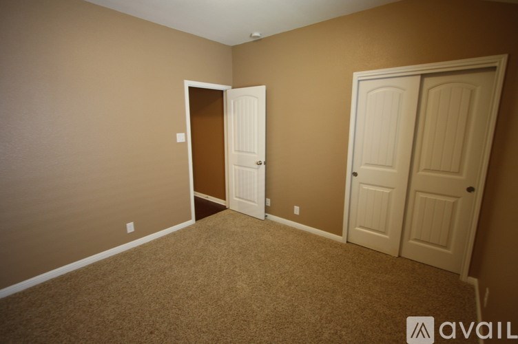A room with two doors and a carpeted floor.