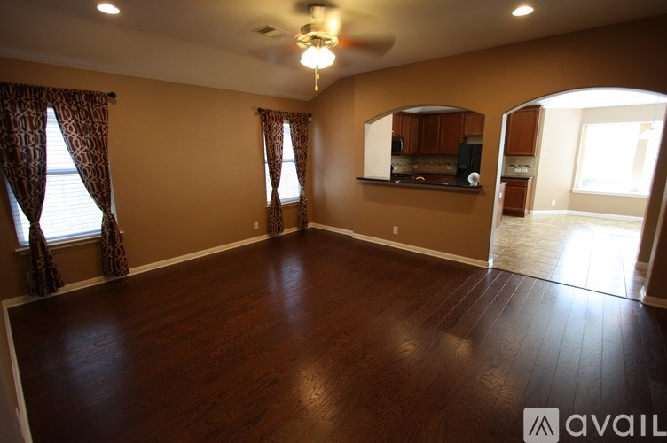 A room with a ceiling fan and wooden flooring.
