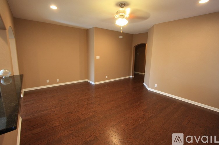 A room with wooden flooring and a ceiling fan.